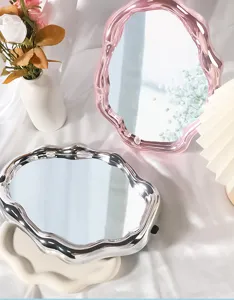 Cloud-shaped electroplated makeup mirrors in pink and silver on white fabric