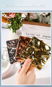 Detailed view of square wavy electroplated handheld makeup mirrors in gold and rose gold.