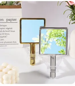 Detail of gold and silver electroplated square handheld mirrors in lifestyle setting