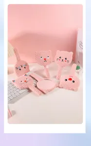 Close-up of adorable pink plush cat handheld mirrors arranged on a stylish white desk