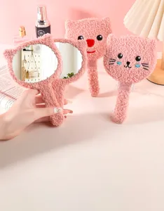 Close-up showing the soft texture of pink plush cartoon bear and cat hand mirrors