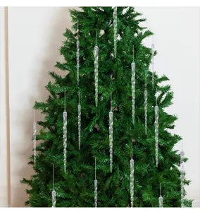 Detalle de adornos navideños de carámbanos transparentes en un árbol de Navidad verde