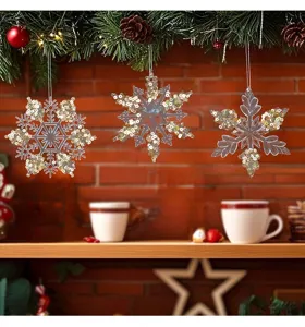 Detailed view of three transparent acrylic snowflake ornaments with gold sequins for Christmas