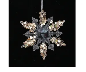 Close-up detail of acrylic snowflake ornament with sparkling gold sequins for tree decoration