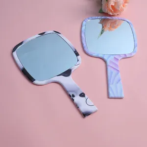 Detailed view of two portable handheld makeup mirrors with dalmatian and watercolor prints