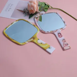Detail view of portable handheld makeup mirrors featuring cute cartoon pattern designs