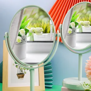 Mint green rotatable desktop makeup mirror with an oval plastic frame and stable base