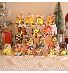 Detailed view of multiple miniature Christmas resin houses with warm LED glowing lights.