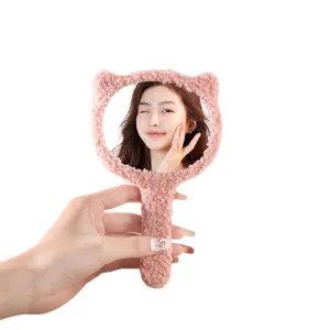 Soft pink plush handheld makeup mirror with cute bear ears for portable vanity use