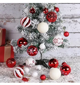Variety of red and white Christmas ball ornaments on a snowy tree