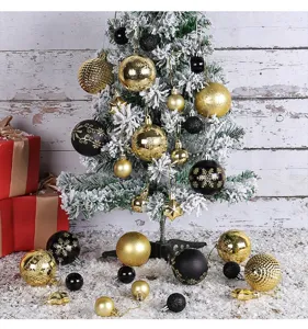 Detail view of black and gold Christmas ornaments hanging on a snow-covered tree.