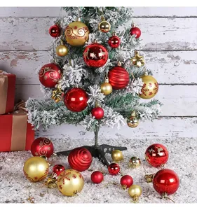 A festive arrangement of red and gold Christmas ball ornaments on a frosted tree