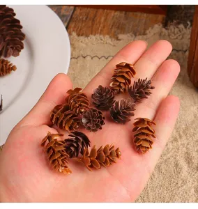 Detailed macro shot of various small decorative plastic pinecones held in an open hand
