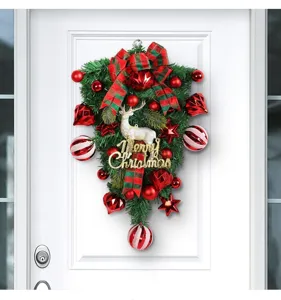 Detailed shot of an upside-down Christmas wreath featuring a white reindeer and red balls