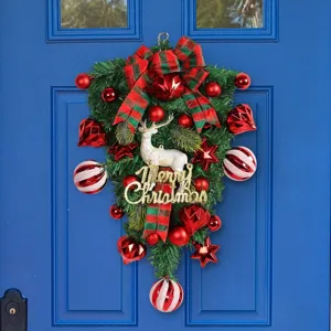 Festive Christmas reindeer teardrop wreath with red ornaments on a blue door background.