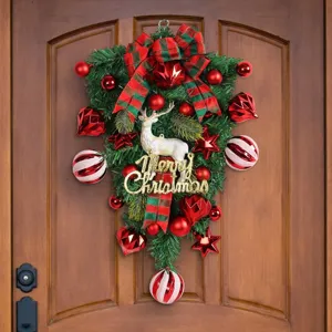 Festive Christmas reindeer teardrop swag with red ornaments hung on a wooden door
