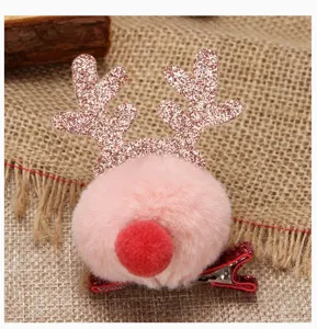 Detailed macro view of a Christmas reindeer hair clip with pink fluffy pom pom ball