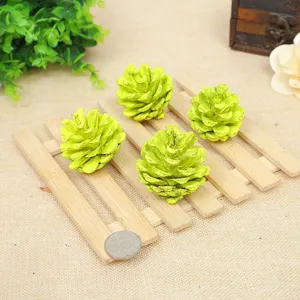 Close-up of lime green decorative pinecones on wood pallet for DIY Christmas decor
