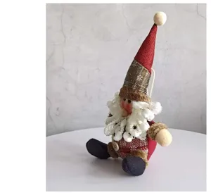 Close-up detail of a handmade Christmas plaid gnome doll with fluffy beard and tall red hat
