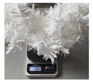 Vue détaillée d'une couronne de Noël artificielle blanche pesée sur une balance numérique