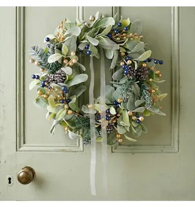 Festive Christmas wreath with lamb's ear leaves and berries on a vintage green door