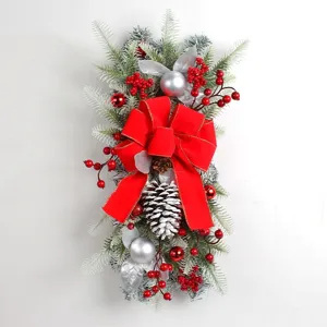 Detailed view of Christmas hanging decoration with red bow, pine cones and berries
