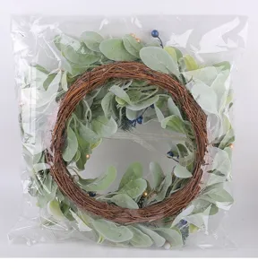 Detail view of artificial lamb's ear and berry wreath in clear plastic packaging.