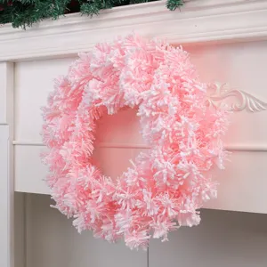 Couronne de Noël artificielle rose et blanche sur un manteau de cheminée blanc