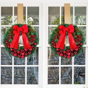 Set van twee kerstkransen met rode bessen, ballen en strikken voor raamdecoratie.
