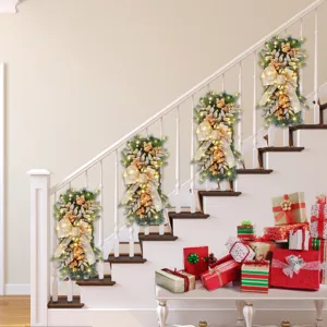 Guirlandes de Noël à LED festives avec nœuds dorés sur une rampe d'escalier blanche.