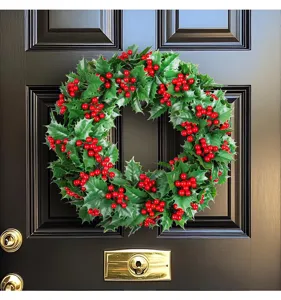 Detailed view of realistic Christmas holly wreath with red berries on a black door