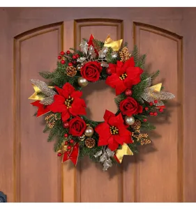Detailweergave van een kerstkrans met rode kerststerren, dennenappels en gouden bladeren