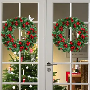 Pair of artificial Christmas wreaths with holly leaves and red berries for door decor