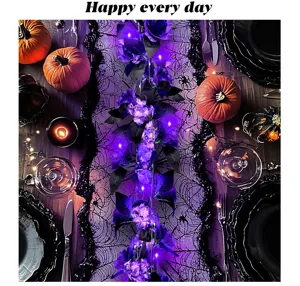 Halloween tafeldecoratie met lichtgevende paarse kunstmatige rozenslinger en pompoen