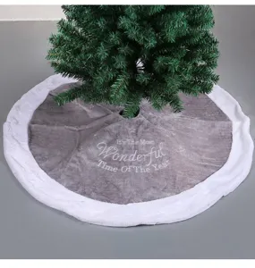 Detail of grey plush Christmas tree skirt with white faux fur border and embroidery