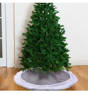Grey and white plush Christmas tree skirt mat on a wooden floor in a living room setting