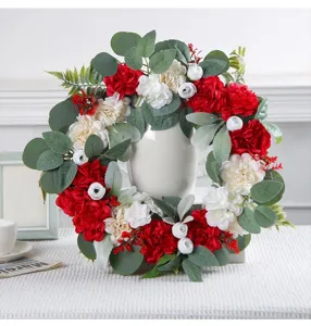 Detail of a red and white peony flower wreath placed over a white vase on a decorated table
