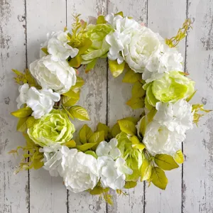 Elegant white and lime green peony artificial flower wreath on rustic wooden background