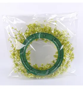 Detail van kunstmatige groene krans in een transparante plastic verpakkingstas