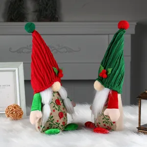Pair of cute Christmas gnomes with red and green hats and cherry pattern decor