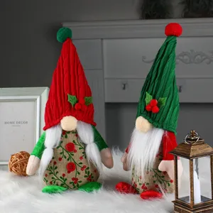 Pair of cute red and green Christmas gnomes with holly berries for festive desktop decoration