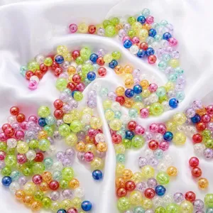 Mixed colorful acrylic cracked bubble round beads scattered on white silk for DIY jewelry making