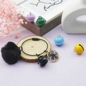 Vue détaillée de cloches en fer DIY colorées avec pompon noir et breloque fleur