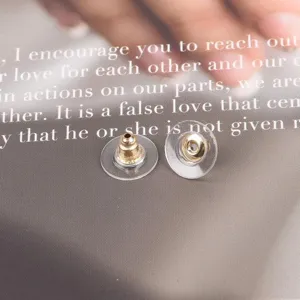 Macro detail view of clear silicone earring backs with gold-tone metal core inserts