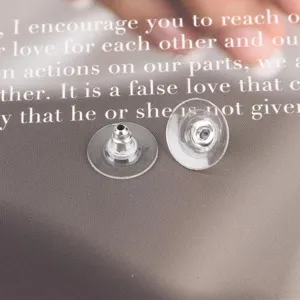 Detailed view of clear silicone and metal earring backs for DIY jewelry making.