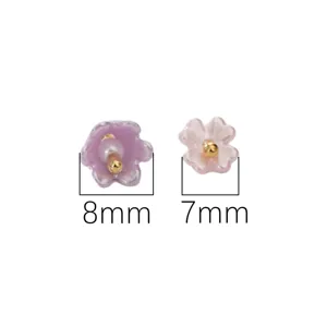 Macro detail of 8mm and 7mm flower-shaped acrylic beads with imitation pearl center