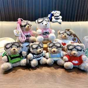 Adorable plush teddy bear keychains wearing goggles and colorful knitted sweaters