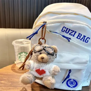 Cool plush bear keychain with goggles and heart sweater on a white backpack