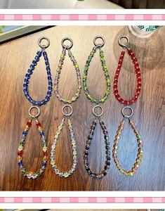 Vue détaillée de dragonnes de téléphone en perles de cristal carrées colorées sur bois