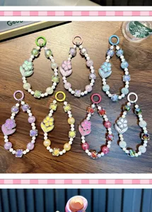 Collection of luminous flower beaded phone chains in various colors on wood surface